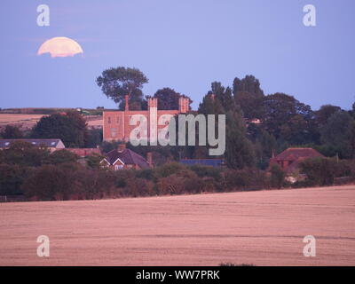 Eastchurch, Kent, Großbritannien. 13. September, 2019. UK Wetter: Die vollständige Harvest Moon gesehen steigende über historische Shurland Halle (wo Henry VIII seine Flitterwochen verbracht) in Eastchurch, Kent an diesem Abend. Credit: James Bell/Alamy leben Nachrichten Stockfoto