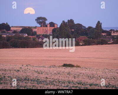 Eastchurch, Kent, Großbritannien. 13. September, 2019. UK Wetter: Die vollständige Harvest Moon gesehen steigende über historische Shurland Halle (wo Henry VIII seine Flitterwochen verbracht) in Eastchurch, Kent an diesem Abend. Credit: James Bell/Alamy leben Nachrichten Stockfoto