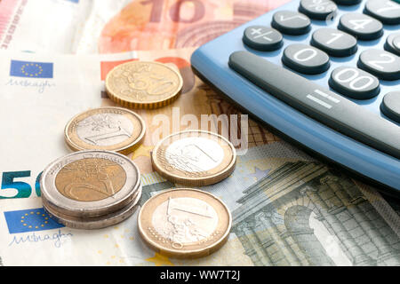 Euro Münzen auf Euro-banknoten und Taschenrechner Stockfoto
