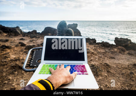 Arbeit und Aufenthalt mit Internet und Laptop Konzept verbunden. Hand auf der Tastatur Entspannen und Arbeiten vor dem Ozean. Natur Outdoor Alternative für Reisende genießen einen freien Lebensstil Stockfoto