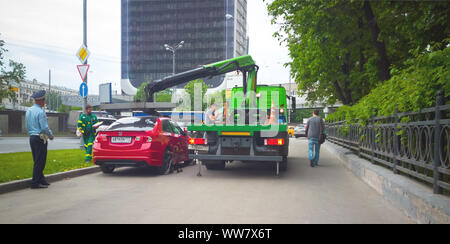 Moskau, Russland, 2018: Abschleppwagen evakuiert das Auto auf dem Bürgersteig der Stadt geparkt Stockfoto