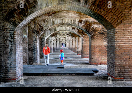 Kinder im Innenraum Fort Jefferson wandern unter gemauerten Bögen auf einer Familie Tagesausflug nach Dry Tortugas National Park von Key West, Florida erkunden. Stockfoto