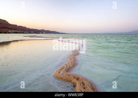 Israel, South District, Ein Bokek. Salzlagerstätten im Toten Meer bei Sonnenuntergang. Stockfoto