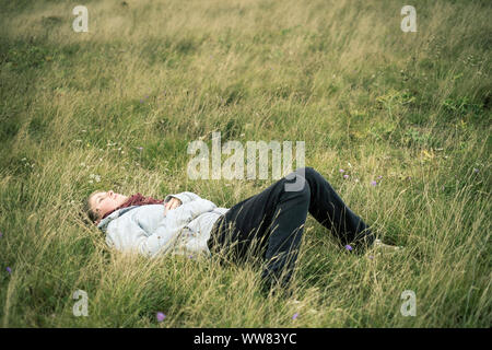 Junge Frau im Gras liegend Tagträumen, Revel, Tarn, Frankreich Stockfoto