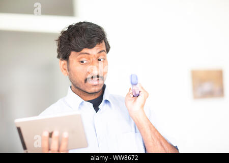 Junger Mann beobachten zu einer Tablette mit einem Wischer Stockfoto