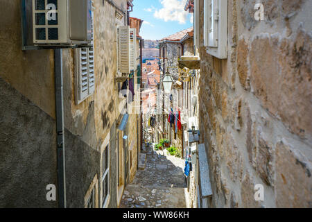 Bergab auf einem steilen und schmalen Straße in Dubrovnik, die von Mauern umgebene Stadt an der kroatischen Adriaküste. Stockfoto