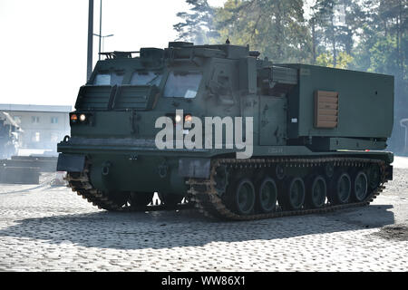 Ein M270 Multiple Launch Rocket System, das mit dem 41. Field Artillery Brigade zugewiesen wird, bewegt sich der eine Schiene Warenkorb an der 7th Army Training Befehl Kopfform, Grafenwöhr, Deutschland, Sept. 11, 2019. (U.S. Armee Foto von Gertrud Zach) Stockfoto