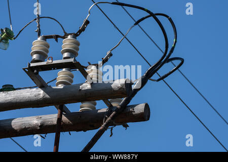 Nahaufnahme der alte Strom Post mit Drähten auf Isolatoren in sonniger Tag an klaren, wolkenlosen Himmel Stockfoto