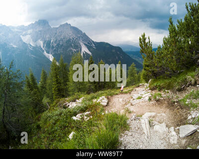 Junge Frau in den Bergen vor. Alpen, Italien, Dolomiten. Junge Mädchen Reisende sitzen mit Blick auf die Dolomiten Alpen Italien und Stockfoto