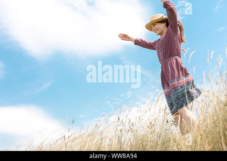 Junge Frau, die an der Klippe und schaut in die Ferne Stockfoto