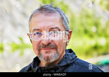 - Nahaufnahme Portrait von ein intelligenter Mann, mit feinen Gesichtszügen, Brillen mit einer Schnur und gutmütigen Aussehen, gegen die backgrou Stockfoto