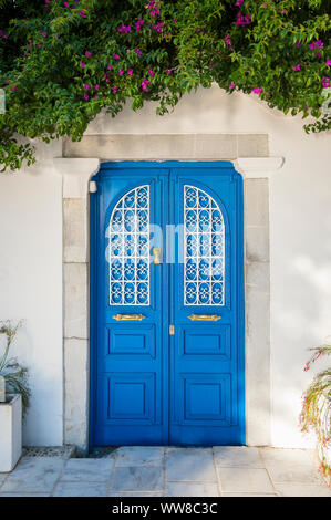 Typisch mediterranes Dorf Szene in weiß getünchten Wänden und blauen Tür von üppigem Grün in der touristischen Ortschaft Bodrum, Türkei gerahmt Stockfoto