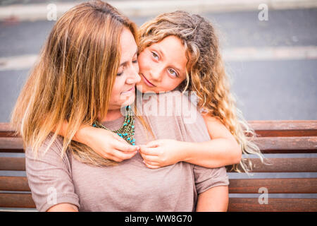 Familie Paar Mutter und Tochter zusammen im Freien happy Freizeitaktivität umarmen und genießen den Tag des Sommers, bevor sie wieder in die Schule und den Winter, blond kaukasischen Mamma und Mädchen Stockfoto