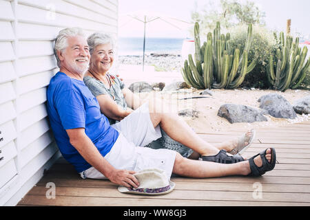 Gerne älteres Paar lachend auf dem Boden auf holzbohlen an einem Sommertag Stockfoto
