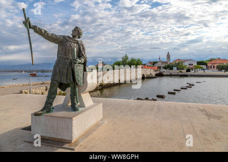 Denkmal von branimir von Kroatien in Nin, auf dem Hintergrund der alten Brücke, die die Stadt mit dem Festland verbindet, Nin, Gespanschaft Zadar, Dalmatien, Kroatien Stockfoto