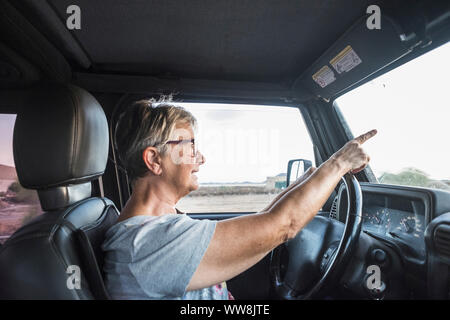 Nach älteren Frau fahren Sie das Auto und achten Sie auf den Verkehr. Stockfoto