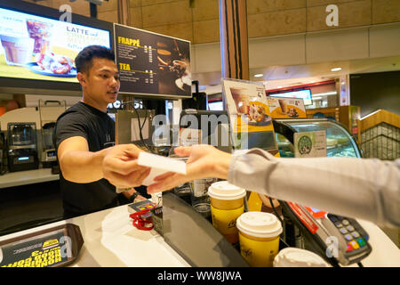 Singapur - ca. April 2019: Arbeiter bei McCafe in Changi International Airport. Stockfoto