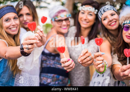 Gruppe von gemischten Alters Frauen von jung bis alt Aufenthalt in Freundschaft und mit Candy Herd lollypop. friedliche und Lebensstil zu Frieden und Liebe wie hippy Stil inspiriert Stockfoto