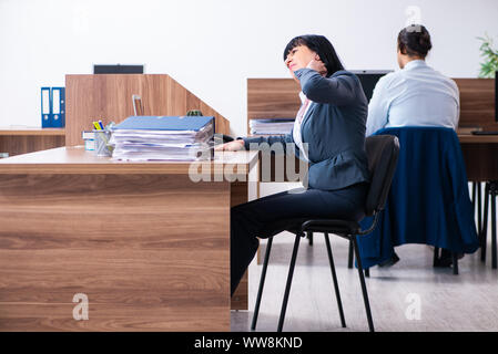Die beiden Mitarbeiter, die sportliche Übungen im Büro Stockfoto