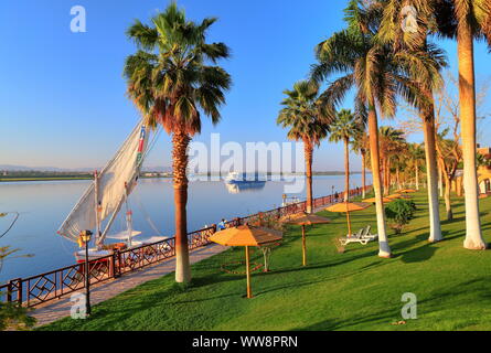 Garten des Mercure Hotel an den Ufern des Nils mit River Cruise Ship, Karnak in der Nähe von Luxor, Oberägypten, Ägypten Stockfoto