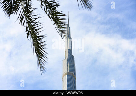 Blick auf den herrlichen Burj Khalifa von einigen Palmen im Vordergrund eingerahmt. Der Burj Dubai, der höchste Turm der Welt. Stockfoto