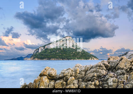 Sonnen Ansicht von Figarolo Insel bei Sonnenuntergang mit bewölktem Himmel und seidigen Wasser in den Vordergrund. Stockfoto