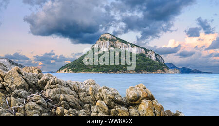 Sonnen Ansicht von Figarolo Insel bei Sonnenuntergang mit bewölktem Himmel und seidigen Wasser in den Vordergrund. Stockfoto