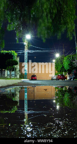 Wasserpfütze in einer Nachbarschaft Straße Stockfoto