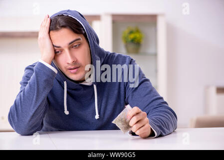 Der junge Mann Probleme mit Drogen zu Hause Stockfoto