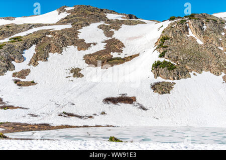 Schneebedeckten Gipfel der Rocky Mountains auf der Spur mit gefrorenen Linkins See und Himmel auf Independence Pass in der Nähe von Aspen, Colorado im Frühsommer 2019 mit Schnee Stockfoto