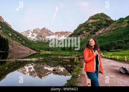 Kastanienbraune Glocken in Aspen, Colorado an der blauen Stunde im Juli 2019 Sommer und Mond Reflexion bei Sonnenaufgang mit Frau trinkt Kaffee oder Tee am Morgen Stockfoto