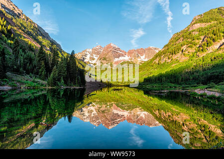 Maroon Bells See bei Sonnenaufgang Panoramablick in Aspen, Colorado mit Rocky Mountain Peak und Schnee in Juli 2019 Sommer und lebendige Licht Reflexion auf w Stockfoto