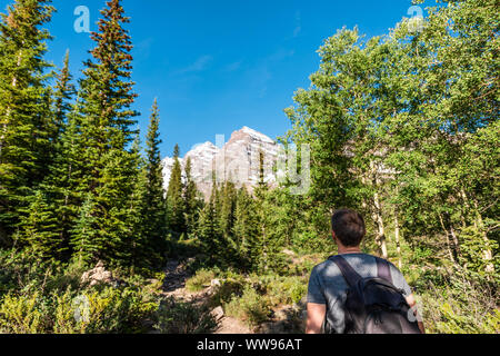 Maroon Bells Gipfelblick in Aspen, Colorado mit touristischen Mann Rucksack Wanderer suchen im Juli 2019 Sommer auf dem Weg weg weg großem Betrachtungswinkel Stockfoto