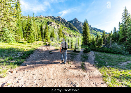 Maroon Bells Trail in Aspen, Colorado mit touristischen Mann Rucksack Wanderer wandern in Juli 2019 Sommer auf dem Weg Straße großem Betrachtungswinkel Stockfoto