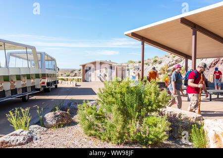 Jensen, USA - 23. Juli 2019: Shuttle Bus stop und Parkplatz durch Steinbruch Besucherzentrum Ausstellungshalle im Dinosaur National Monument Park mit Menschen in Stockfoto