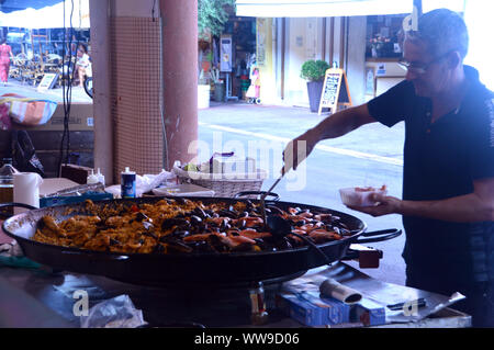 Mann Kochen eine traditionelle spanische Paella in der grossen Pfanne in Provinzmarkt von überdachten Markt, Cannes, Frankreich, EU Stockfoto