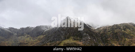 Atemberaubende Moody dramatische Winterlandschaft mountain Bild von schneebedeckten Y Garn in Snowdonia Stockfoto