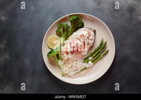 Cremige Knoblauchbutter Toscan Lachsbackofen in einer köstlichen Zitronencreme Sauce mit Spargel, Kirschtomaten, Brokkoli gesunde Ernährung Omega 3 Lachs gebacken Stockfoto