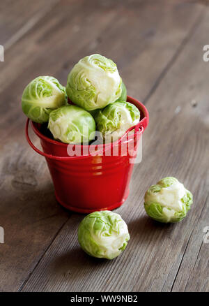 Rosenkohl in einem Eimer auf einem alten Holztisch Stockfoto