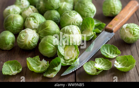 Rosenkohl mit Blättern und messer an holz Stockfoto