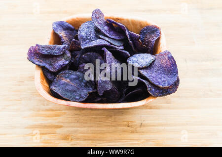 Ein Haufen von violetten Kartoffelchips auf hölzernen Hintergrund Stockfoto