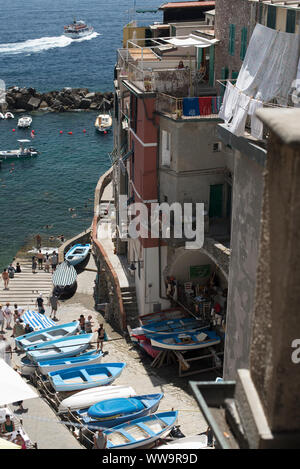 Riomaggiore, Italien - Juli 2, 2018: Badegäste sammeln an einem Meer boatramp in Cinque Terre, die fünf traditionellen Fischerdörfer entlang der italienischen Rivie Stockfoto