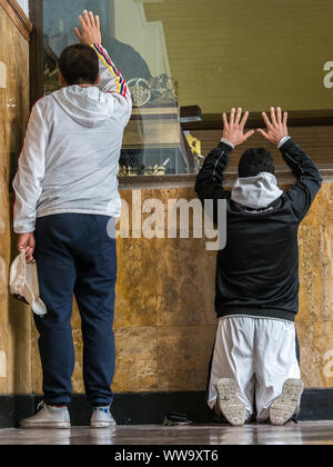 Männer beten im Heiligtum "El Senor Caido' aus dem 17. Jahrhundert auf dem Palácio de Monserrate Hill in Bogotá, Heiligtum des Christus unter dem Kreuz zusammenbricht, Co Stockfoto