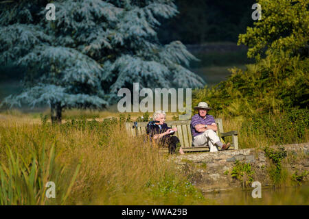 Zwei Rentner sitzen auf einer Parkbank an der Wasserseite. Stockfoto