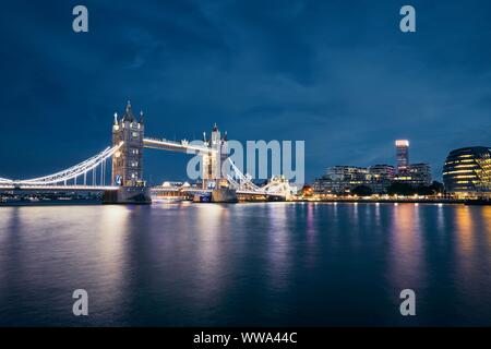 Nacht Blick von der Tower Bridge gegen Stadtbild mit Rathaus bei Nacht. London, Vereinigtes Königreich.