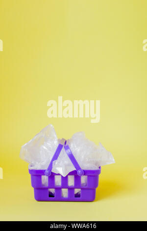 Polyäthylenbeutel im Warenkorb auf gelben Hintergrund. Stockfoto
