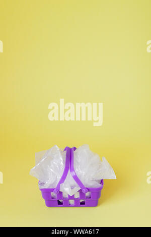Polyäthylenbeutel im Warenkorb auf gelben Hintergrund. Stockfoto