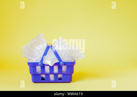 Polyäthylenbeutel im Warenkorb auf gelben Hintergrund. Stockfoto