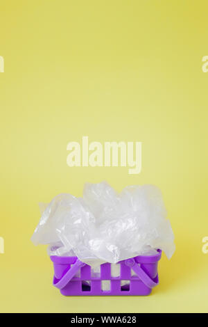 Polyäthylenbeutel im Warenkorb auf gelben Hintergrund. Stockfoto