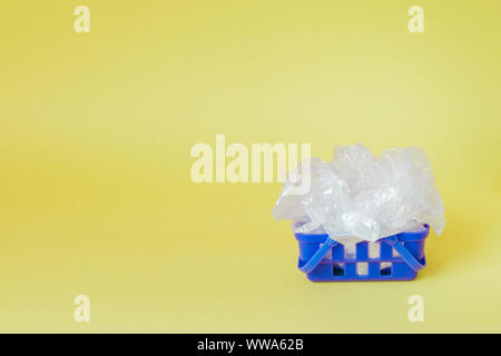 Polyäthylenbeutel im Warenkorb auf gelben Hintergrund. Stockfoto